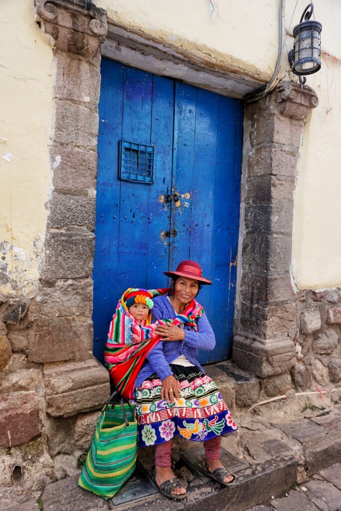 A local Peruvian woman dressed in traditional colorful Andean style clothing.