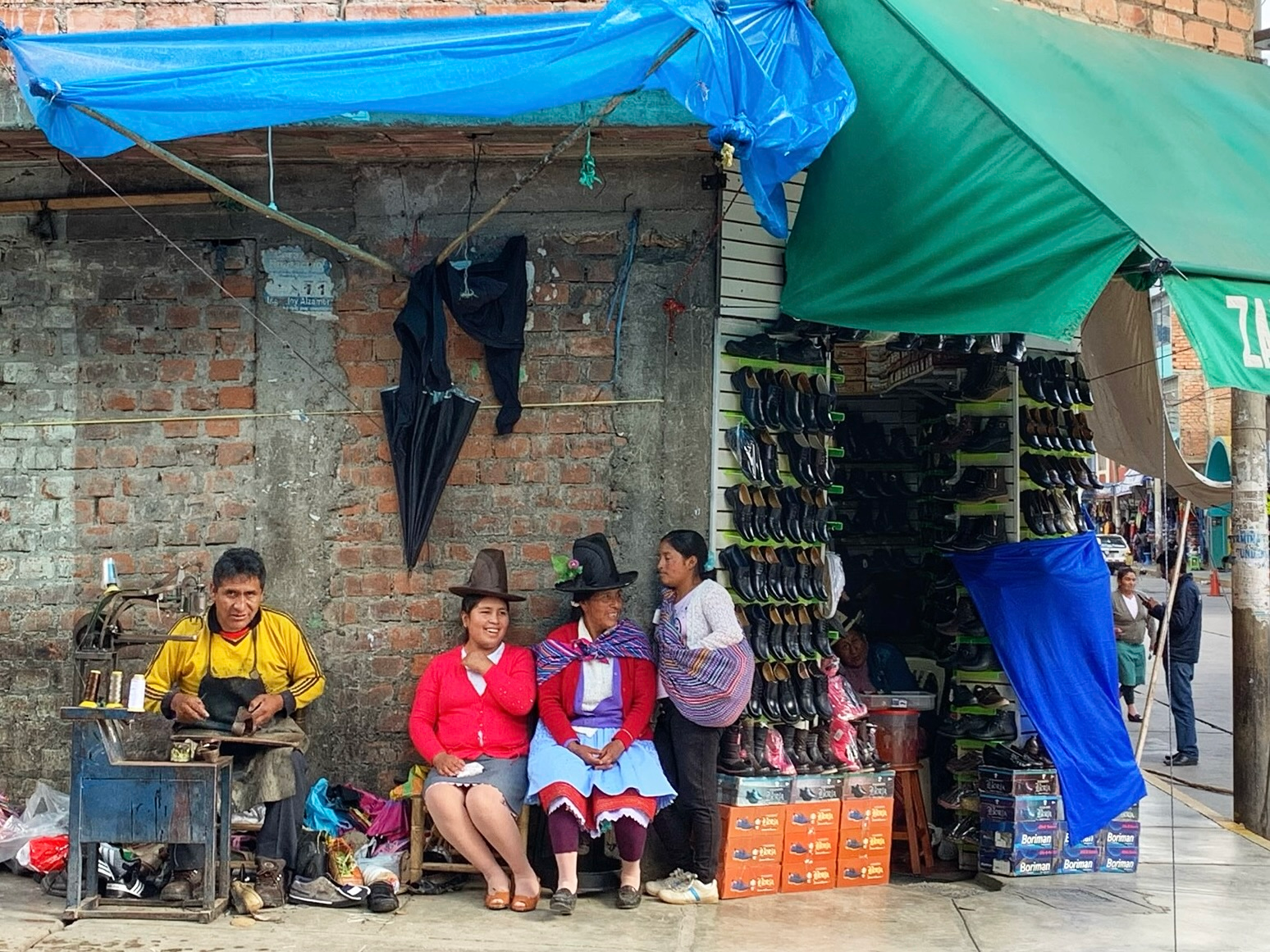 Locals sitting outside of a shoe shop in Huaraz, Peru