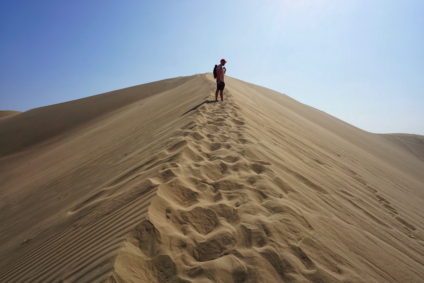 Walking up to the top of the sand dunes in Huacachina