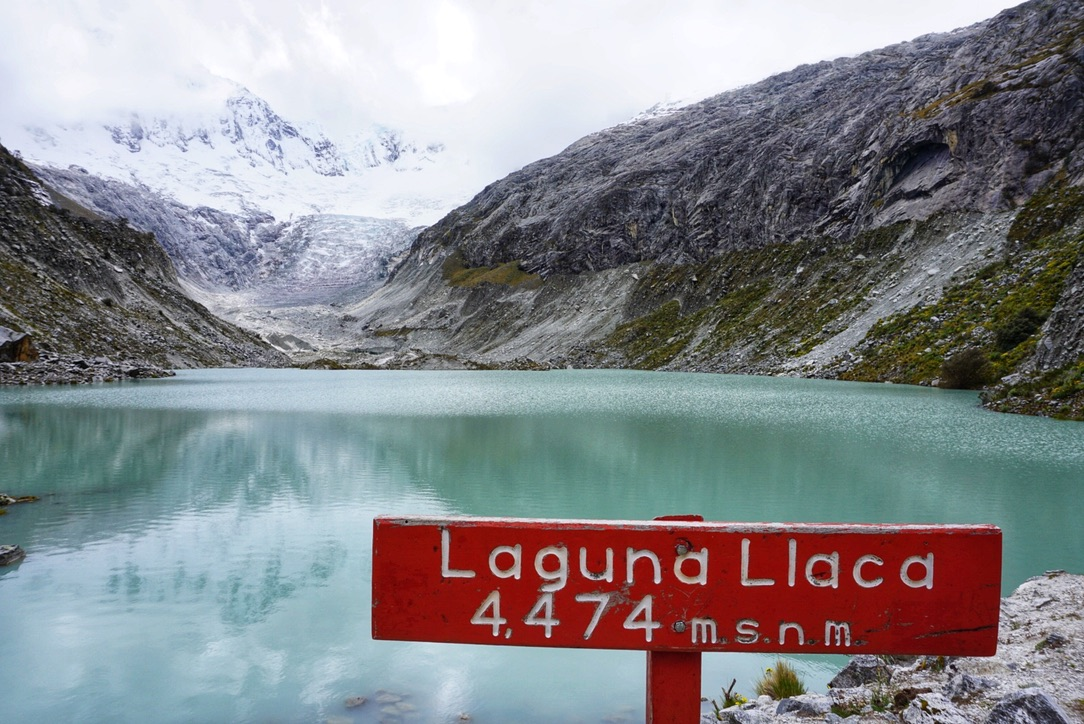 The sign for Laguna Llaca looking over the lake 