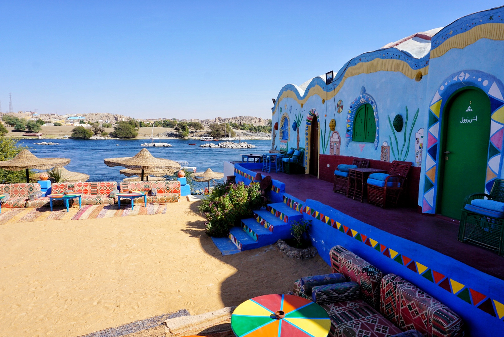A colorful building in the Nubian Village with the Nile River in the background
