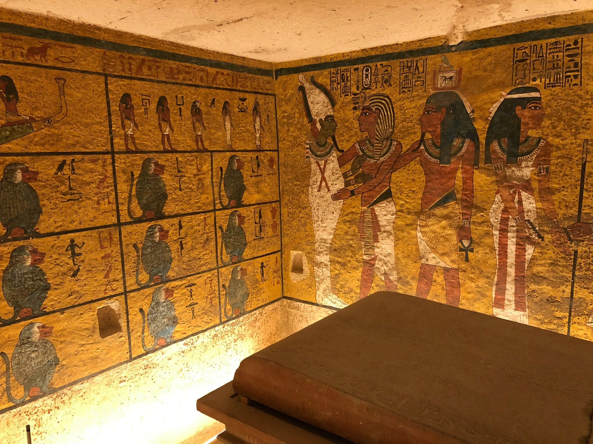 A view of King Tut's tomb with colorful wall mural in the background