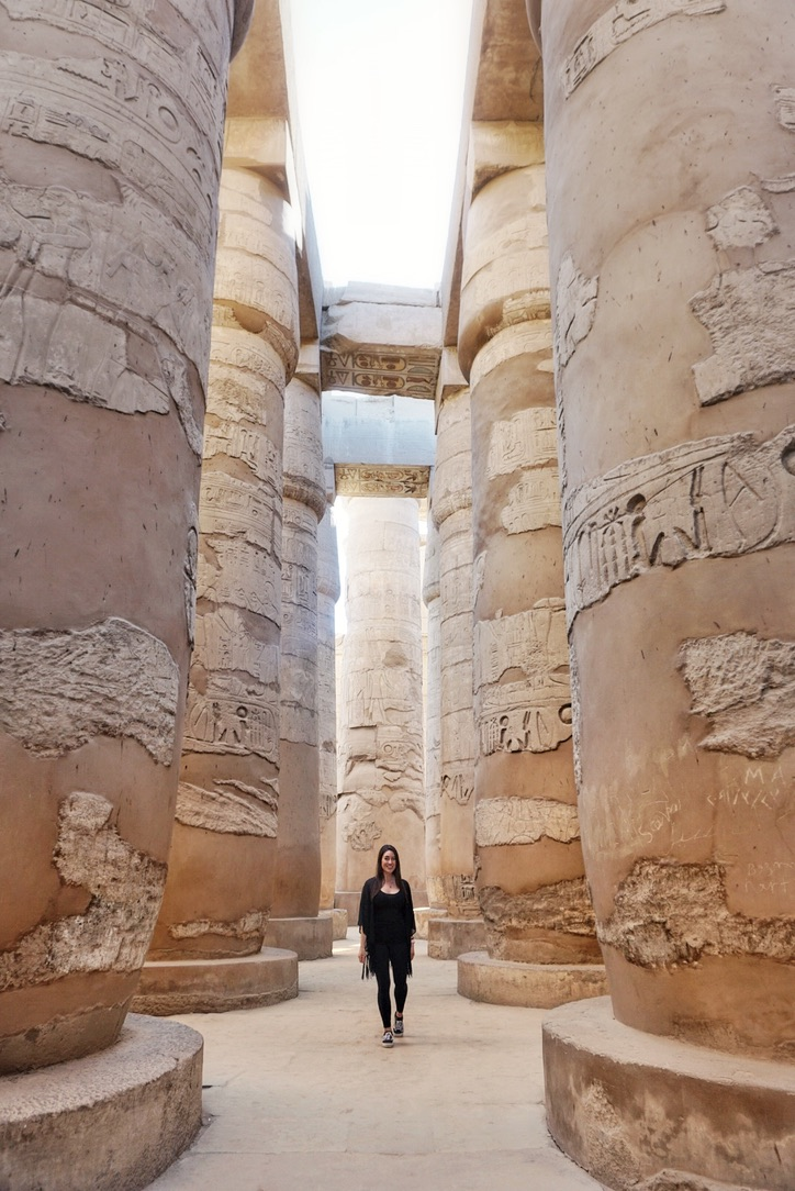 Walking through a massive column lined hallway at Karnak Temple
